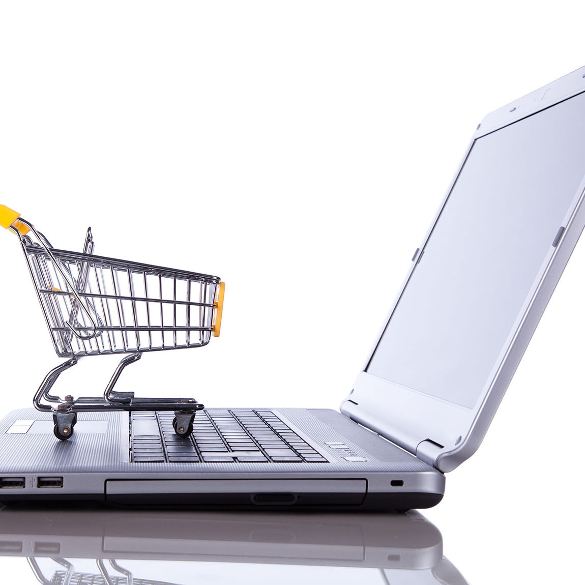 Shopping-cart,Over,A,Laptop,Isolated,On,White,With,Reflection